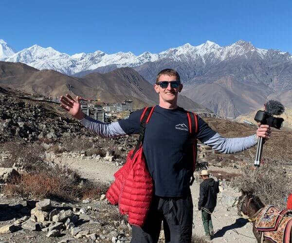 Ollie Moto stood in front of the Himalayas whilst filming in Nepal.